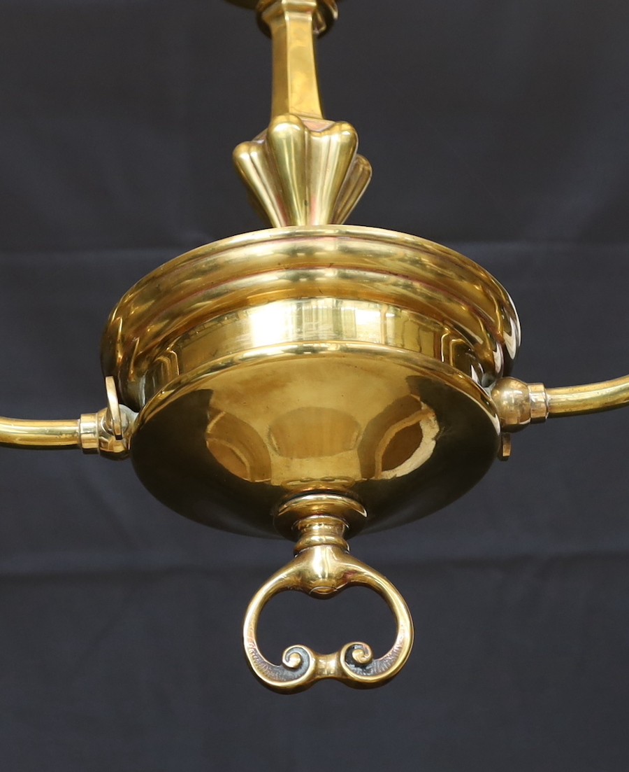 An early 20th century English brass twin branch light fitting with amber tinted tall glass shades height to top of fitting 50cm, width 77cm